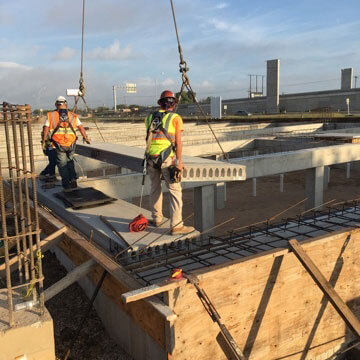 Here workers place a piece of the lid over the water quality pond.